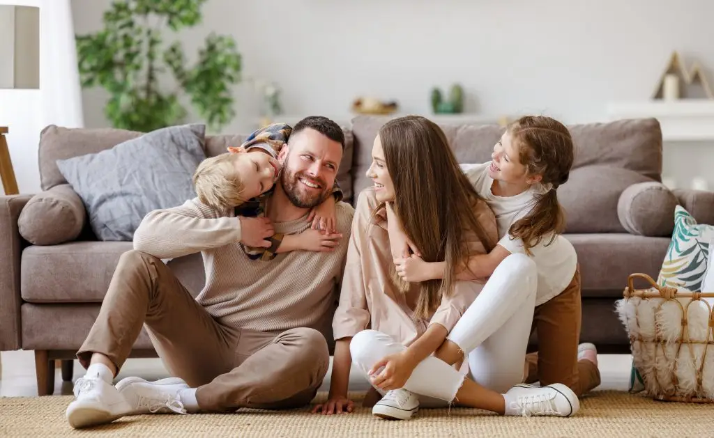 Glückliche Familie sitzt auf dem Fussboden
